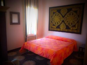 a bedroom with a bed with an orange comforter and a window at Bed & Breakfast Don Carlos in San Martino di Lupari +14 photos