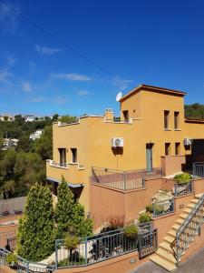 una casa gialla con balcone e scale di Villa Vista al mar a Segur de Calafell