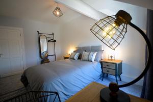 1 dormitorio con 1 cama y 1 mesa con lámpara en Heritage Holiday Accommodation en Pembrokeshire