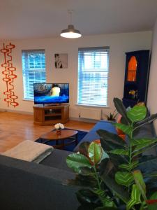 een woonkamer met een bank en een flatscreen-tv bij Ideal Apartment - Sleeps 6 - Parking in Barnsley