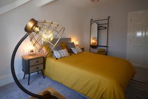 a bedroom with a yellow bed with a lamp on it at Heritage Holiday Accommodation in Pembrokeshire