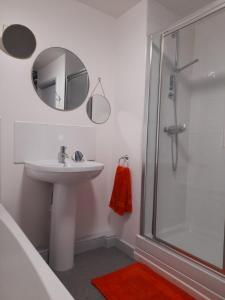 een badkamer met een wastafel en een douche met een spiegel bij Ideal Apartment - Sleeps 6 - Parking in Barnsley