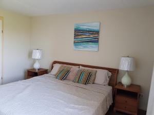 a bedroom with a white bed with two lamps at Fabulous Ocean View Apartment in Secure Resort, 5 min Walk to Beaches & Restaurants in Willemstad