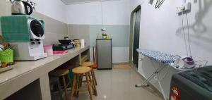 a kitchen with a counter and stools in a room at Haney Twin Homestay in Jertih