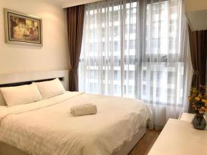 een slaapkamer met een wit bed en een raam bij VINHOME TIME CITY CĂN HỘ 2 PHÒNG NGỦ in Hanoi