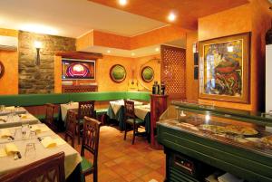 a dining room with tables and chairs in a restaurant at Locanda Barchetta - Room Rental in Bellagio