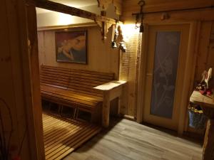 a wooden bench in a room with a door at Garnì Defrancesco in Campitello di Fassa