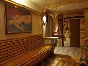 a bench in a room with a painting on the wall at Garnì Defrancesco in Campitello di Fassa
