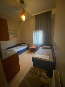 a small room with two beds and a desk at Hotel Santos in Skopje