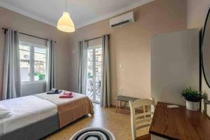 a bedroom with a bed and a desk and a table at EMMANUEL’S COZY HOUSE in Chania Town