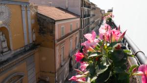 een balkon met roze bloemen bij Sweet Central Hotel in Caserta