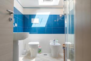 a blue tiled bathroom with a toilet and a sink at casa n'donda in Cuccaro Vetere +46 photos