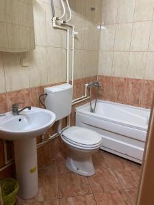 y baño con aseo, lavabo y bañera. en Hotel Santos, en Skopje
