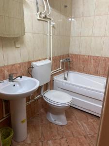 a bathroom with a toilet and a sink and a tub at Hotel Santos in Skopje