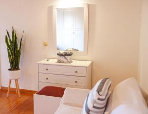 a bedroom with a white dresser and a mirror at Villa Angelo in Kassiopi