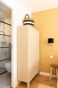 a bathroom with a toilet and a white cabinet at Paradise Beach Studio in Zandvoort