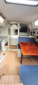 - une vue sur l'intérieur d'un bateau avec une table en bois dans l'établissement Nuit Insolite à Bord d'un voilier Exceptionnel cadre naturel, à Étaples