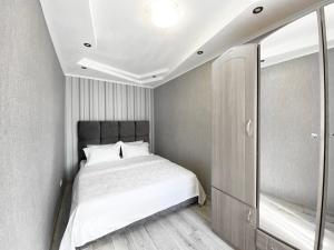 Dormitorio pequeño con cama y espejo en 2-bedroom Lux Most City Area Nebereznaya Riv'era, en Dnipro