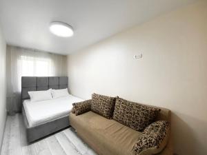 sala de estar con sofá y cama en 2-bedroom Lux Most City Area Nebereznaya Riv'era, en Dnipro