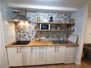a small kitchen with white cabinets and a sink at Casa La Cañada in La Orotava