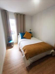 a bedroom with a bed with blue and yellow pillows at Casa La Cañada in La Orotava