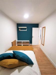 Un dormitorio con una cama con una pared azul. en Casa La Cañada, en La Orotava