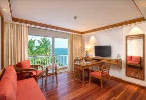 a living room with a couch and a table with a television at Welcomhotel by ITC Hotels, Bay Island, Port Blair in Port Blair