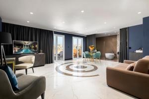 a living room with a couch and a tv and a table at Lure Hotel & Spa - Adults Only in Mellieħa