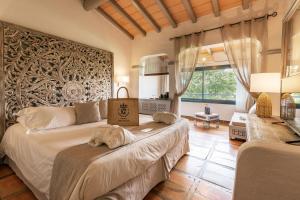 a bedroom with two beds and a large wall at Hôtel Le Roi Théodore & Spa in Porto-Vecchio