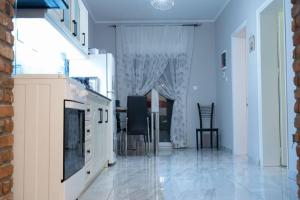 a kitchen with blue walls and a table and chairs at Το άλλο σπίτι... in Aridaia