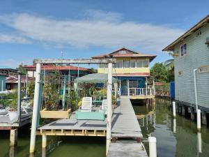 Urania House في بوكاس تاون: رصيف به منزل وكراسي على الماء