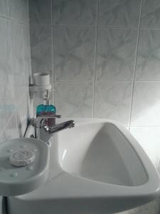 a bathroom sink with a soap dispenser on top of it at CAPTAIN GEORGE in Sougia