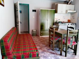 a living room with a couch and a table and a kitchen at CAPTAIN GEORGE in Sougia