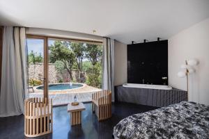 ein Schlafzimmer mit Bett, Badewanne und Fenster in der Unterkunft A SPERANZA Suites avec piscine privative chauffée in Bonifacio + 34 Fotos