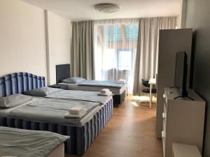 a hotel room with two beds and a television at Pension Lara in Magdeburg