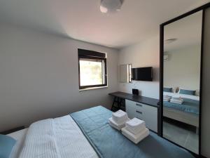 a bedroom with a mirror and a bed and a desk at Apartmani Nerium in Lovište