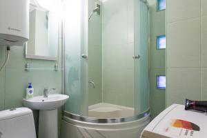 a bathroom with a shower and a toilet and a sink at Nauky avenue in Kharkiv