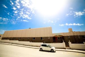 a white car parked in front of a building at Sensi Hotel in Marsaskala