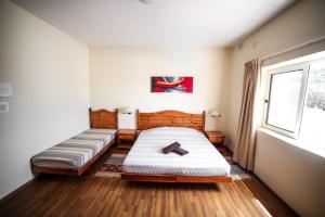 sypialnia z 2 łóżkami i oknem w obiekcie Sensi Hotel w mieście Marsaskala