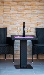 einen Tisch mit einer Flasche Wein und zwei Gläsern in der Unterkunft Apartman Noel Peroj centar in Peroj