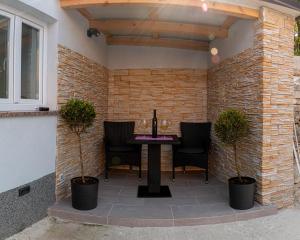 eine Terrasse mit einem Tisch, Stühlen und einer Ziegelwand in der Unterkunft Apartman Noel Peroj centar in Peroj