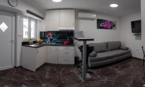 a kitchen and living room with a couch and a table at Apartman Noel Peroj centar in Peroj