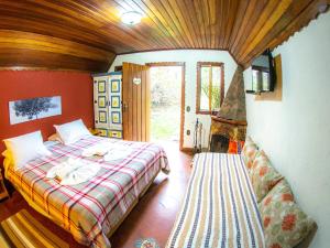 Un dormitorio con una cama y una chimenea. en Villa da Vila, en Monte Verde