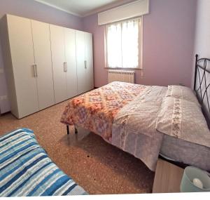 een slaapkamer met een bed en een raam bij Appartamento Dolcefarniente in Lucrezia