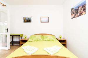 1 dormitorio con 1 cama amarilla y 2 mesitas de noche en Guest House Kola, en Slano