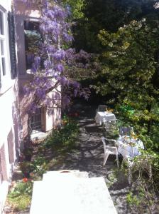 een tuin met een tafel en paarse bloemen bij Garden Studio Apartment Zürichberg in Zürich