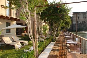 una fila di sedie a sdraio e ombrelloni su un balcone di Corte Regia Relais & Spa a Valeggio sul Mincio