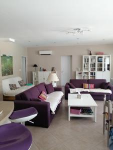 una sala de estar con sofás morados y una mesa. en Villa gonfaron, en Gonfaron