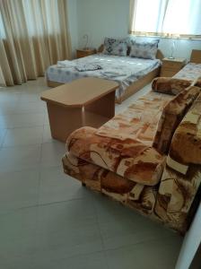 2 Betten und ein Tisch in einem Zimmer in der Unterkunft House of Flowers in Achtopol