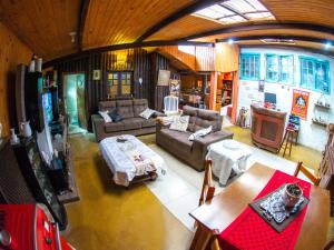 vistas panorámicas a una sala de estar con sofá y mesa en Villa da Vila, en Monte Verde